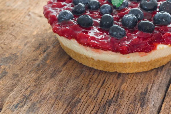 Strawberry cheese pie with fresh blueberry on wood