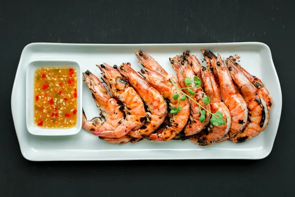 Fresh grilled shrimps, Top view on blak background.Eat with spic