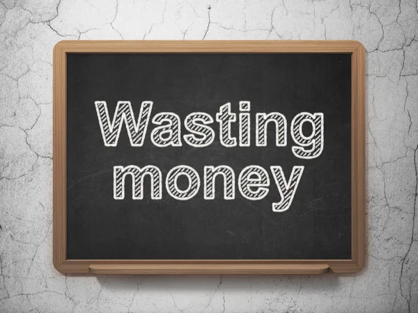 Money concept: Wasting Money on chalkboard background