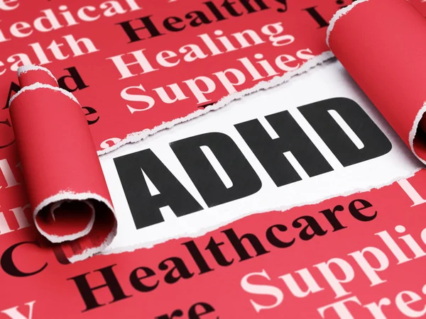 Medicine concept: black text ADHD under the piece of  torn paper