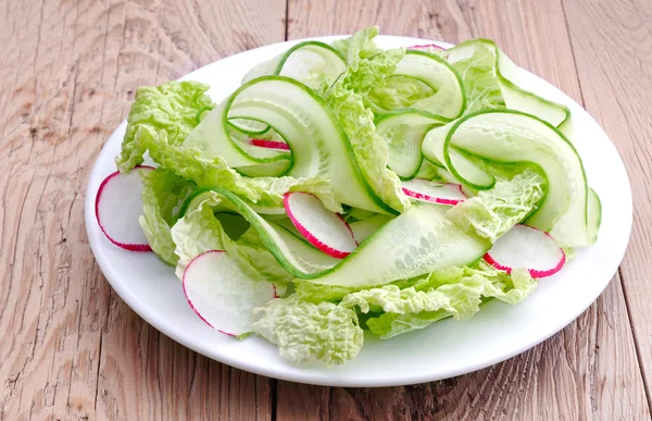 Fresh leaves of chinese cabbage and sliced radish with cucumber.