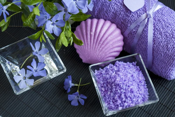 Lavender bath salts with flowers, soap and towel