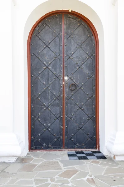 Vintage metal dark grey door decorated with forged grill