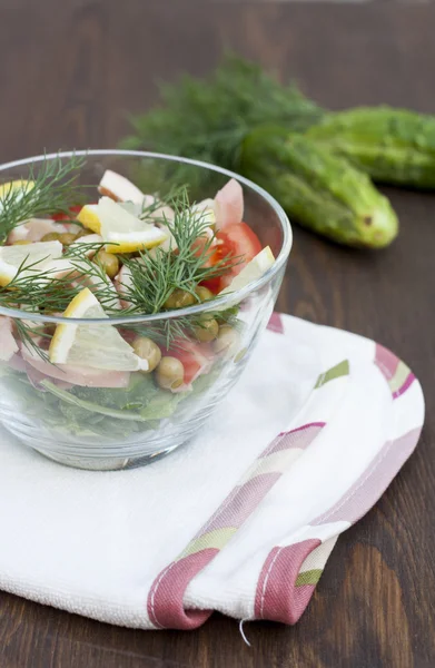 Salad of cooked squid, fresh vegetables and herbs in glass bowl