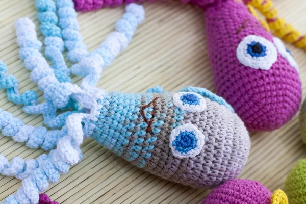 Crocheted woven with colored wool toy octopus close-up, selective focus