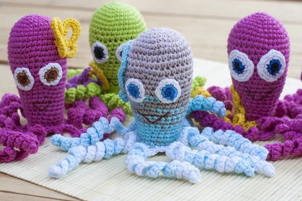 Crocheted woven with colored wool toy octopus close-up, selective focus