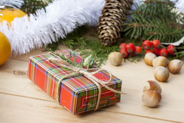 Christmas gift box with New Year\'s and Christmas decoration midst fruits and tinsel.