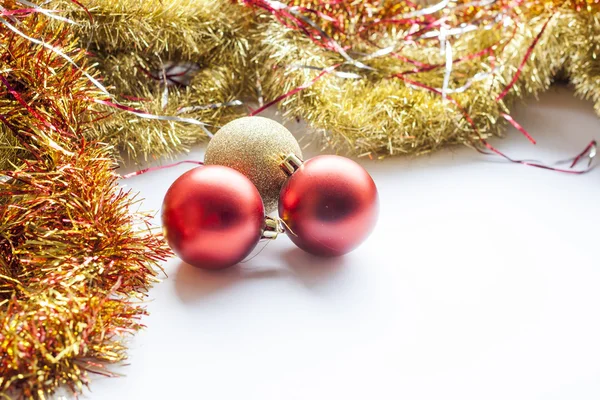 Red and gold decorative Christmas ball and garland on white background