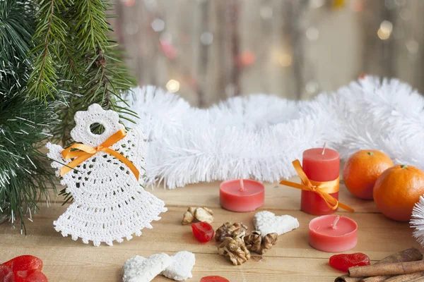 Christmas angel in tree and red candles on colorful background bokeh among Christmas and New Year decor