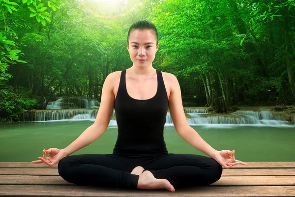 Portrait of asian woman wearing black body suit sitting in yoga