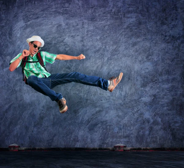 Traveling man jumping mid air with exciting emotion against ceme