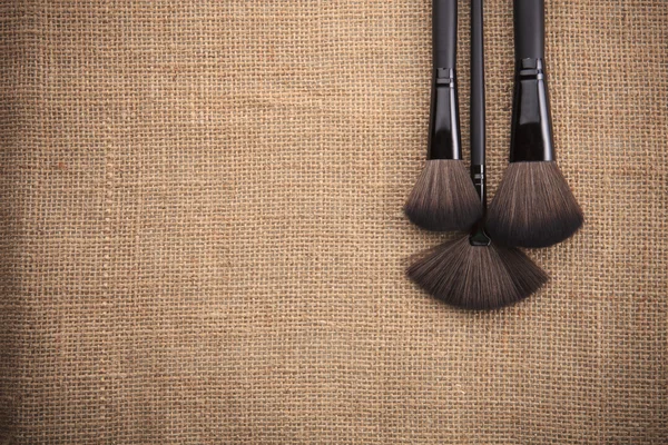 Cosmetic brush set on natural fabric texture with copy space use