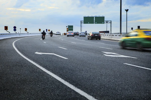 Moving passenger car and motorcycle on bridge way crossing junct