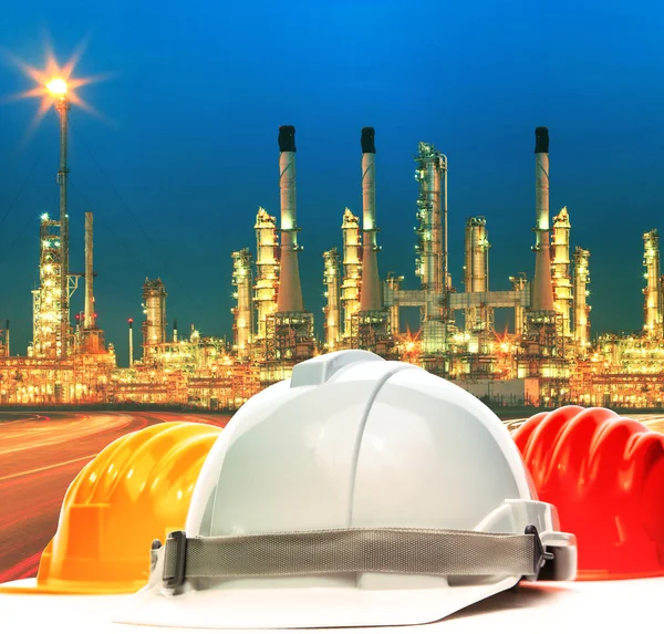 Safety helmet against beautiful lighting of oil refinery plant i