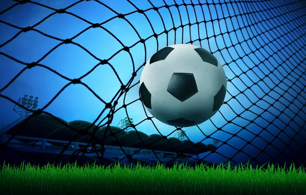 Soccer football in goal net with sport stadium background