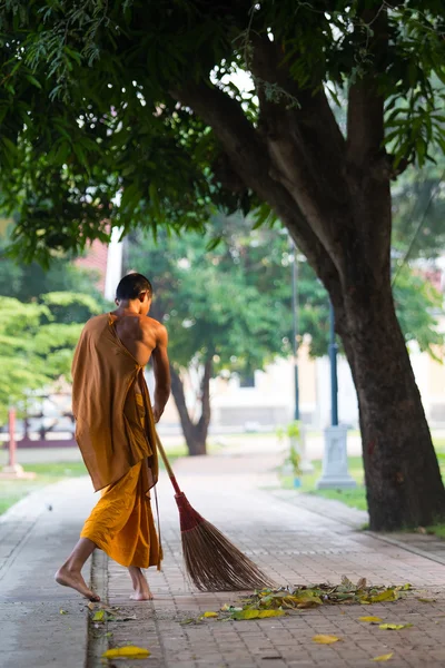 Thai monk daily cleaning temple area