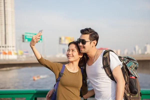 Couples of younger man and woman take a selfie photograph by sma
