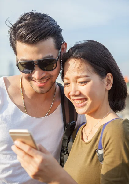 Close up face of younger asian man and woman looking to smart ph