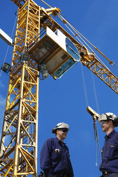 Construction workers and mobile cranes