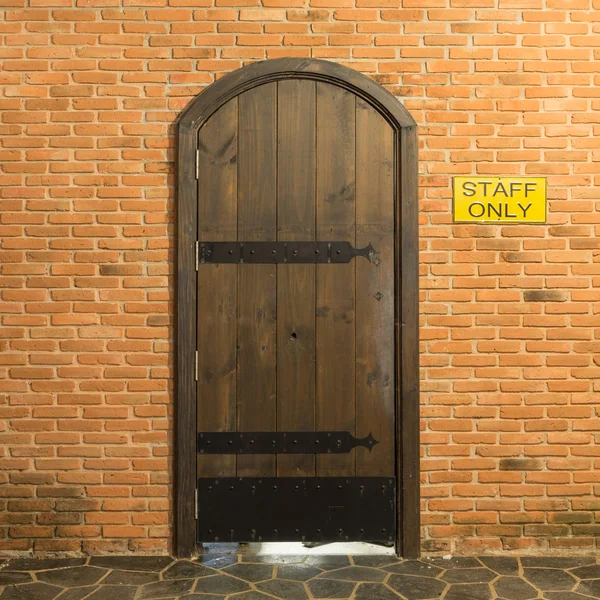 Wood arch door on red brick wall