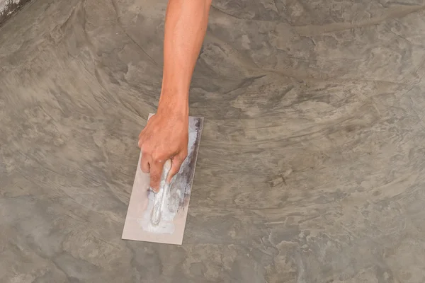 Hand using steel trowel to finish Polished wet concrete surface