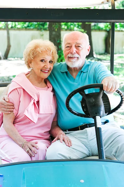 Senior Couple Drives Golf Cart