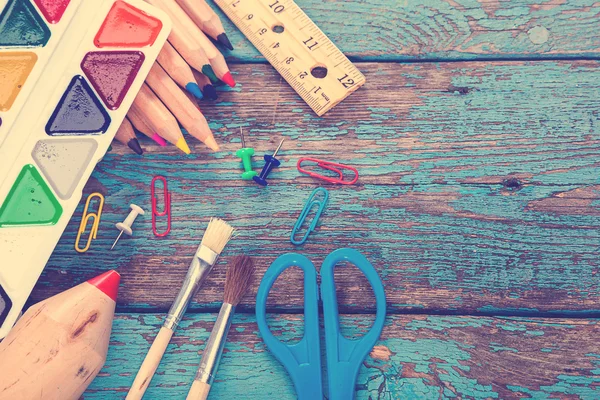 Office or school supplies on wooden planks painted in blue