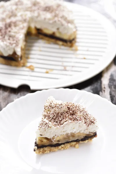 Banoffee wipe cream cake in soft light and selective focus