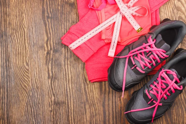 Sports sneakers, tape measuring and sports bra