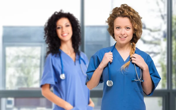 Nurses with stethoscopes looking at camera
