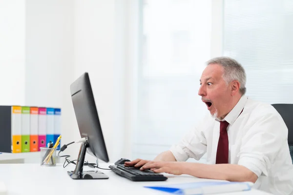Amazed businessman in front of computer