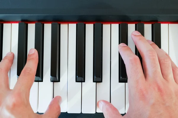 Musician hands playing a piano