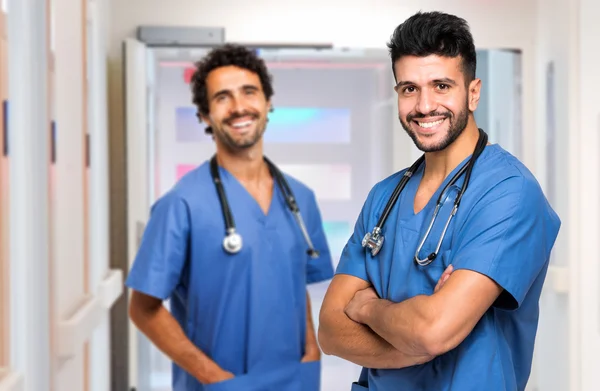Male doctors looking at camera at hospital hall