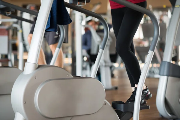 People working out on step machine