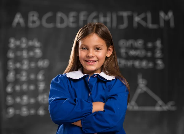 Little student in front of blackboard