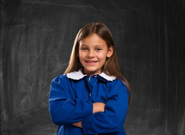 Little student in front of a blackboard