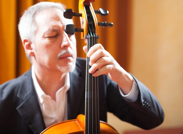 Man playing cello in concert hall