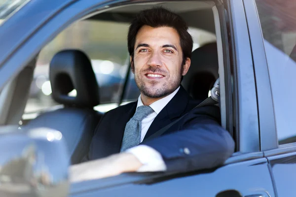Smiling business man driving car