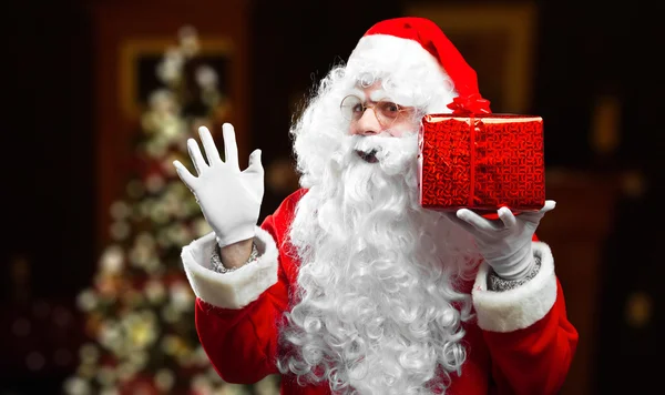Santa Claus in costume holding gift