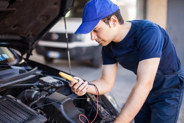 Auto electrician working on car engine