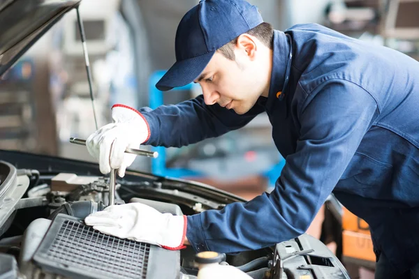 Mechanic working on car in garage