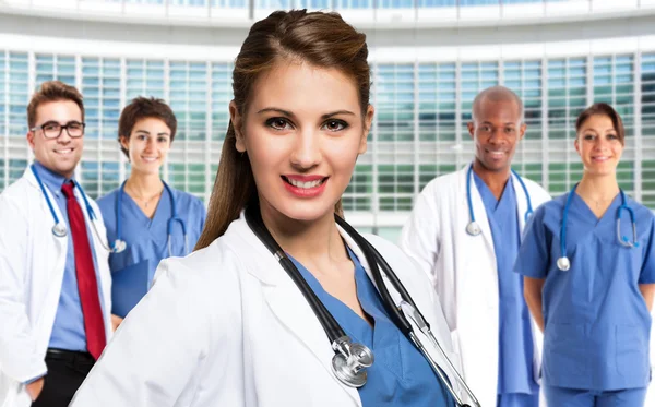 Smiling doctor in front of medical workers