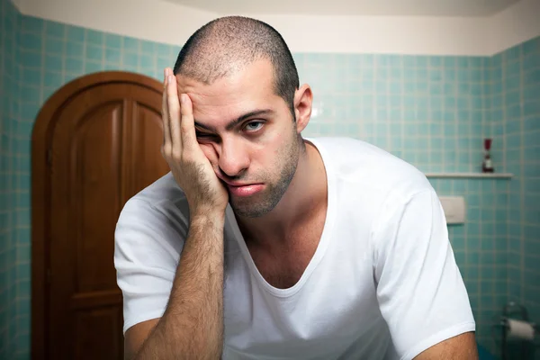 Tired man looking in mirror