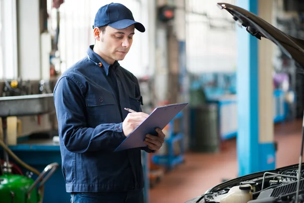 Mechanic writing on clipboard