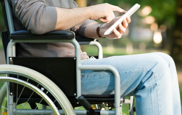 Man using tablet in wheelchair