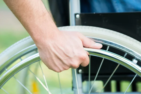 Hand on the wheel of a wheelchair