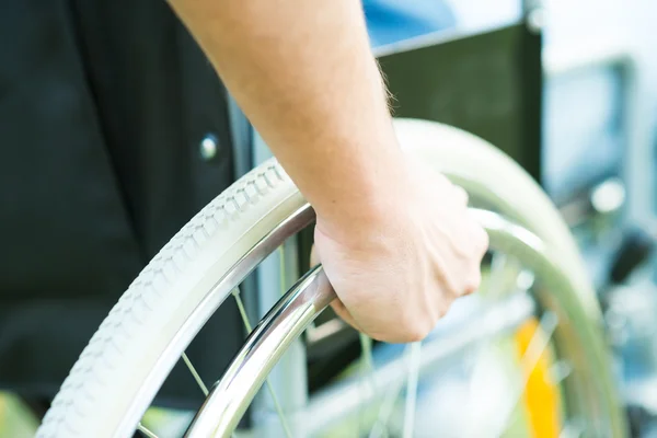 Hand on the wheel of a wheelchair
