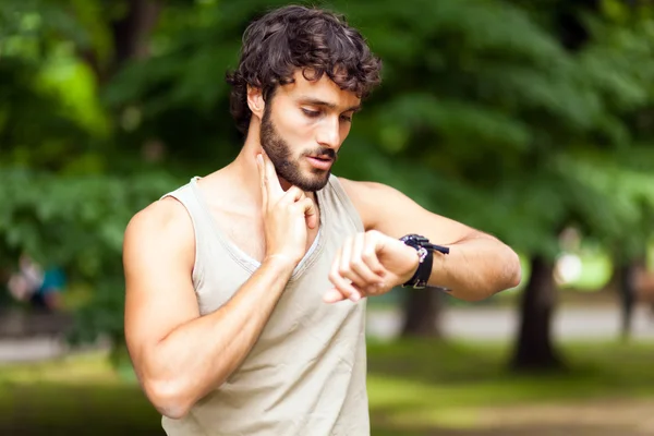 Male runner looking at sports smart watch