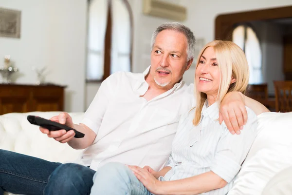 Mature couple watching television