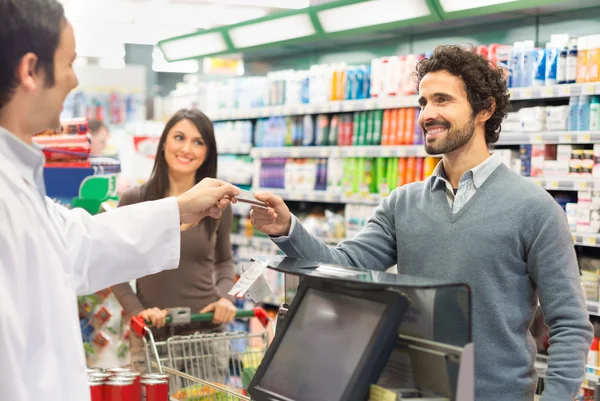 Customer using credit card in supermarket